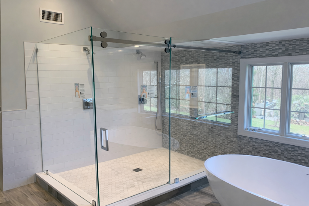 Frameless sliding glass system with smooth, quiet hardware and a built-in towel bar for added convenience.