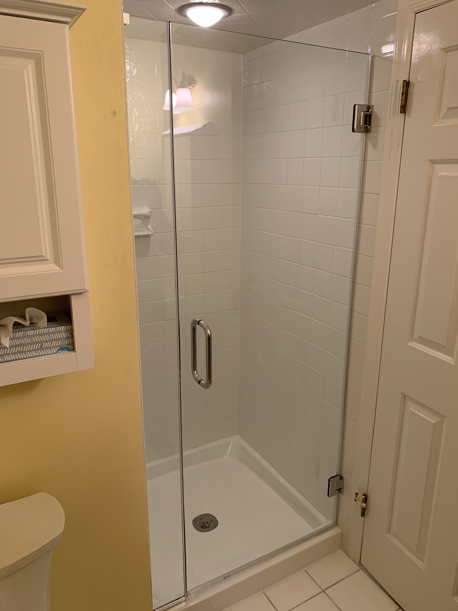 Frameless sliding glass system with smooth, quiet hardware and a built-in towel bar for added convenience.