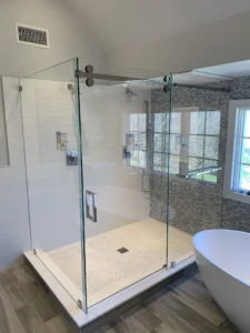 Frameless sliding glass system with smooth, quiet hardware and a built-in towel bar for added convenience.